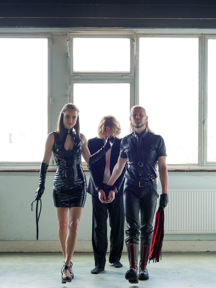 Two Dominants escorting a submissive